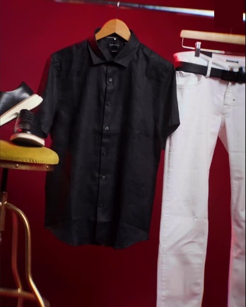 Camisa negra Antony Morato colgada junto a pantalón blanco